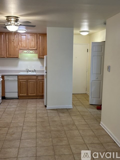 A kitchen with a white fridge and wooden cabinets.