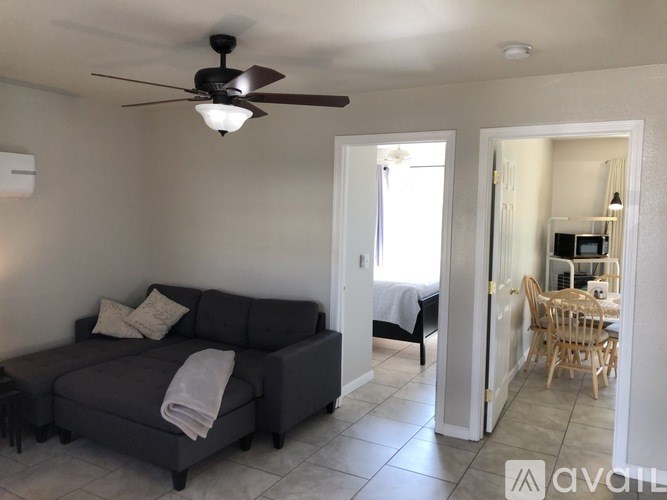 A living room with a grey couch and a ceiling fan.
