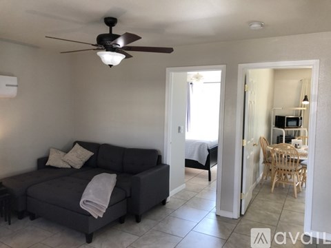 A living room with a grey couch and a ceiling fan.