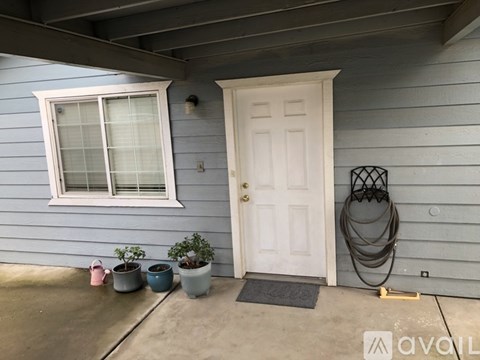 A white door is on the right of a grey wall.
