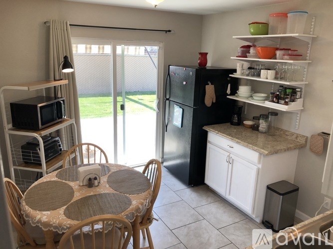 A kitchen with a table and chairs and a refrigerator.
