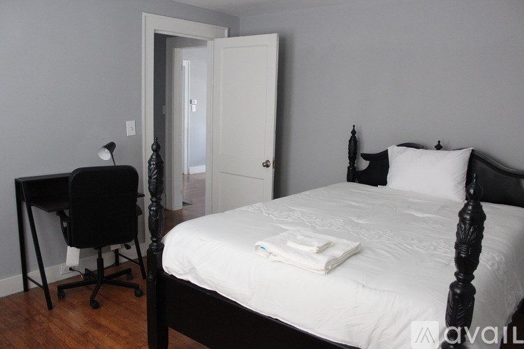 A bedroom with a bed, desk, and chair.