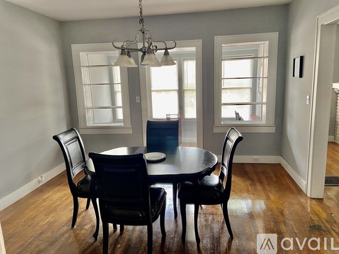 A dining room with a table and chairs.