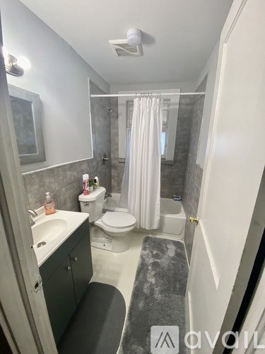 A bathroom with a toilet, sink, and shower.