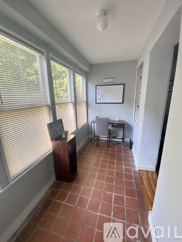 A room with a tiled floor and a window with blinds.