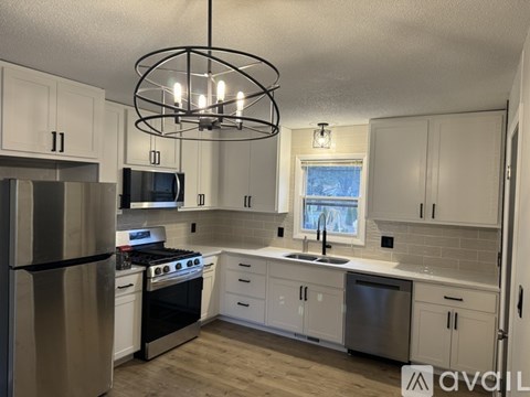 A modern kitchen with stainless steel appliances and white cabinets.