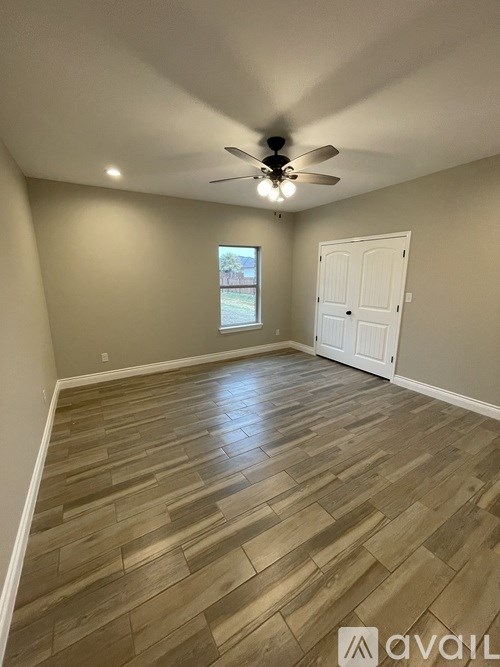 A room with wooden flooring and a ceiling fan.