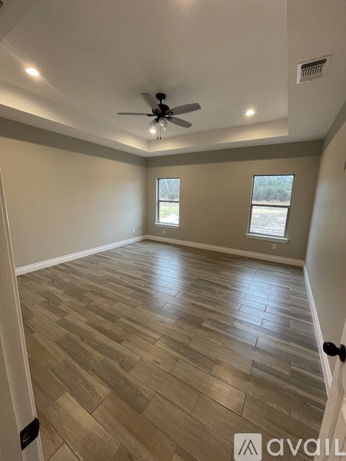 A room with wooden flooring and a ceiling fan.