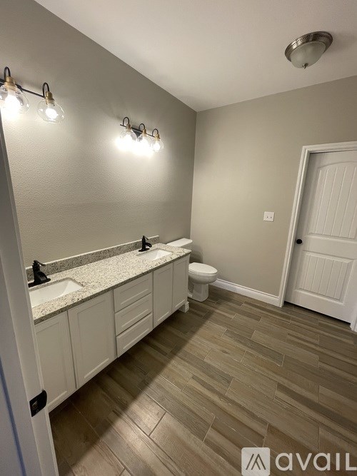 A bathroom with a toilet, sink, and light fixtures.