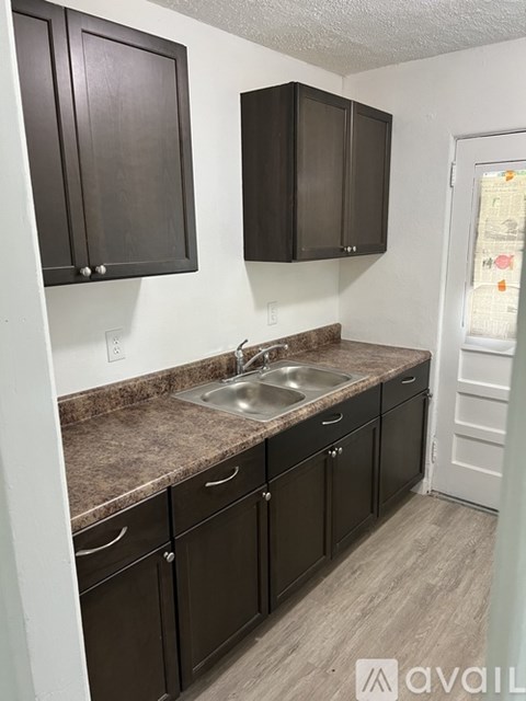 A kitchen with brown cabinets and a granite countertop.