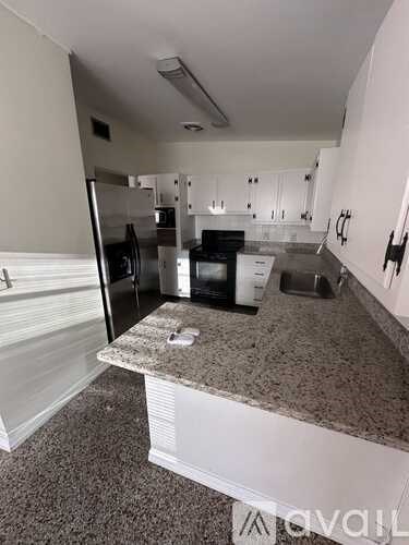 A kitchen with granite countertops and white cabinets.