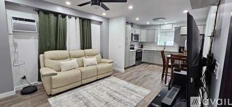 A living room with a beige couch and a television.