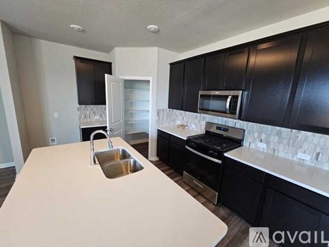 A kitchen with black cabinets and a white countertop.