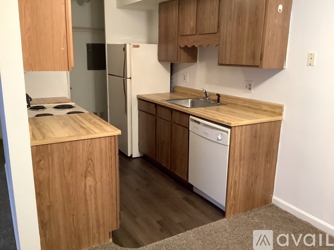 A kitchen with wooden cabinets and a white refrigerator.