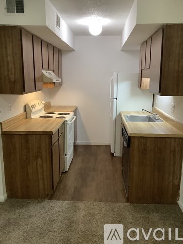 A kitchen with wooden cabinets and a white refrigerator.