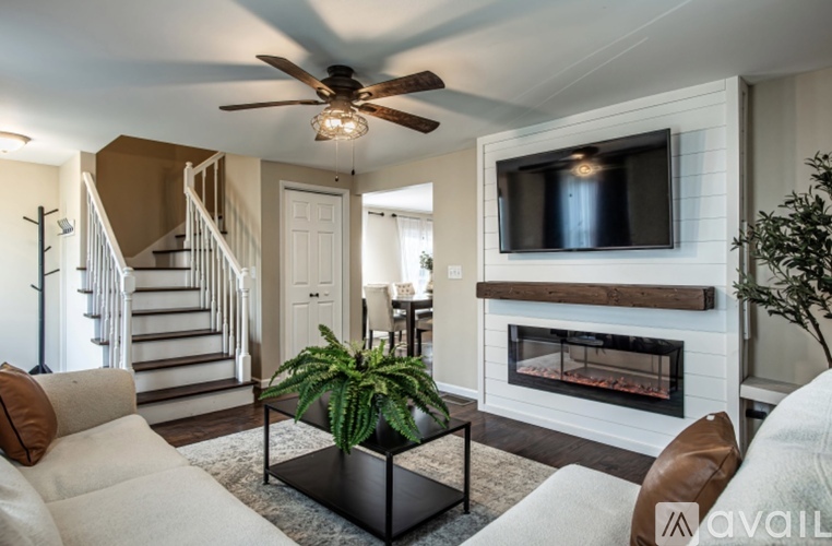 A living room with a fireplace and a television mounted on the wall.