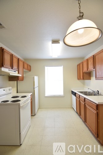 A kitchen with brown cabinets and a white stove top oven.