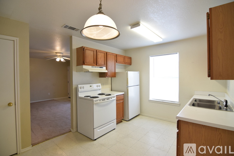A kitchen with a stove, refrigerator, and cabinets.