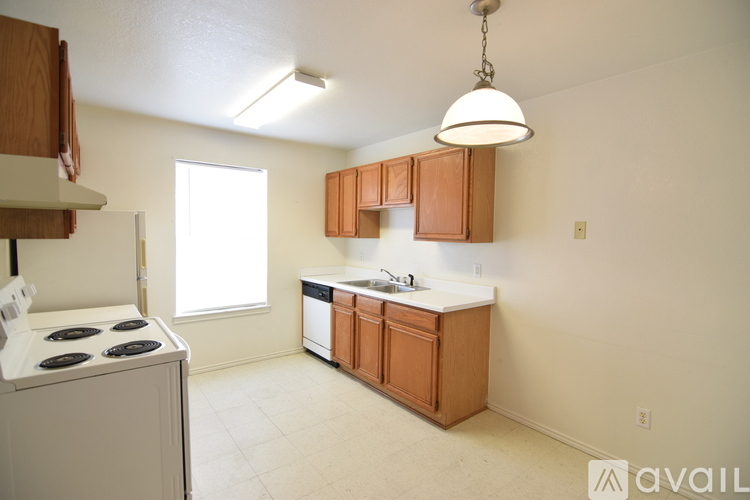 A kitchen with a white stove and wooden cabinets.