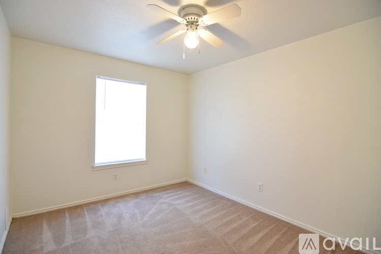 A room with a ceiling fan and a window.