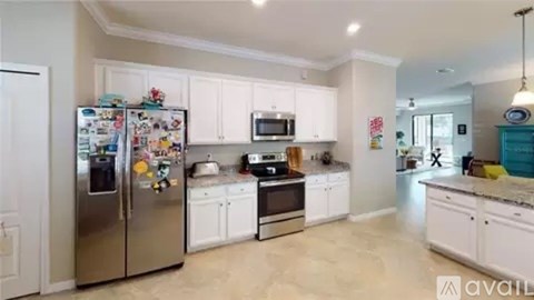 A kitchen with a fridge, microwave, oven and other appliances.