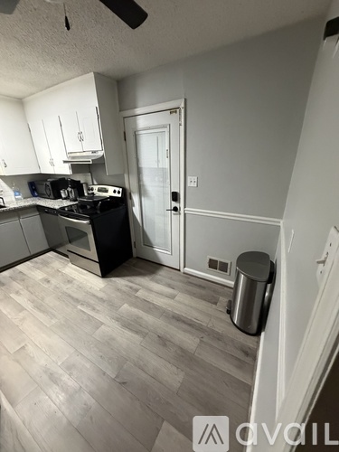 A room with a ceiling fan and wooden flooring.