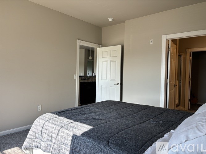 A bedroom with a bed and a door.