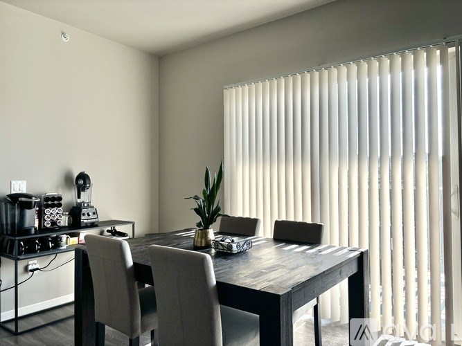 A dining room with a wooden table and chairs.