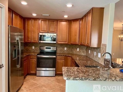 A kitchen with wooden cabinets and granite countertops.