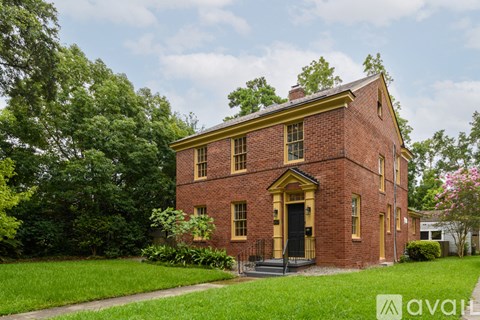 A red brick house with a black door and windows.