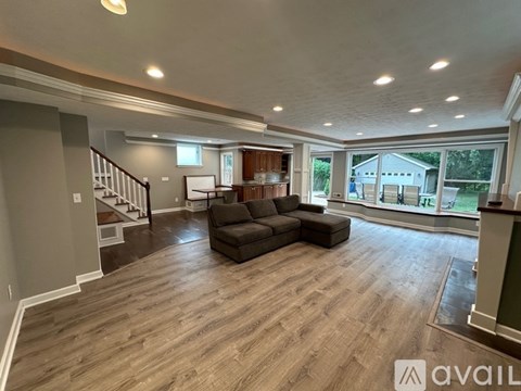 A spacious living room with a couch and a staircase.