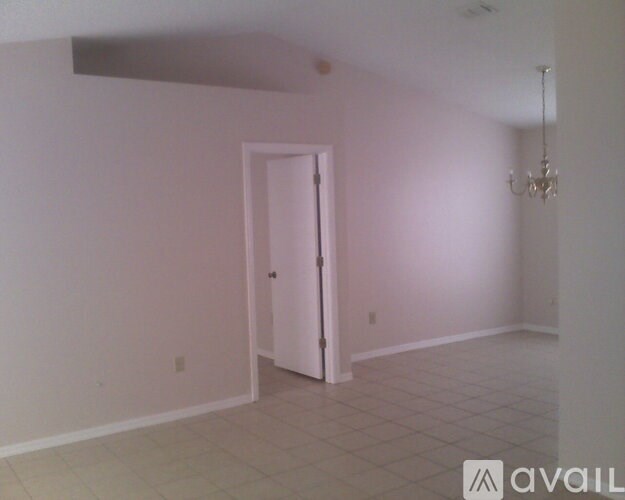 A room with a door and a chandelier.