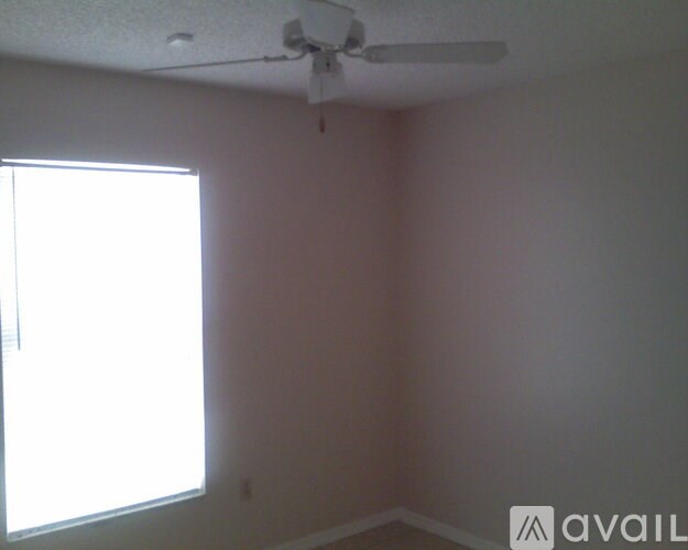 A room with a window and a ceiling fan.