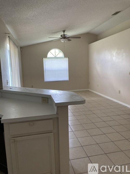 A room with a window and a fan on the ceiling.