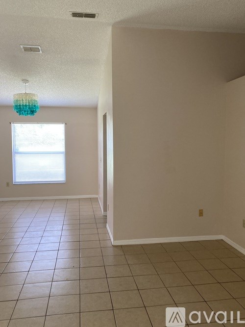 A room with a window and a chandelier.