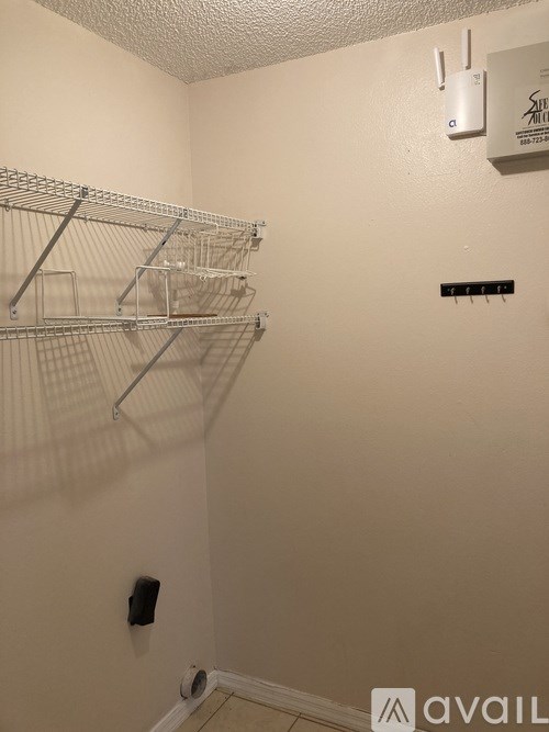 A small room with a white ceiling and a white wall with a black sign on it.