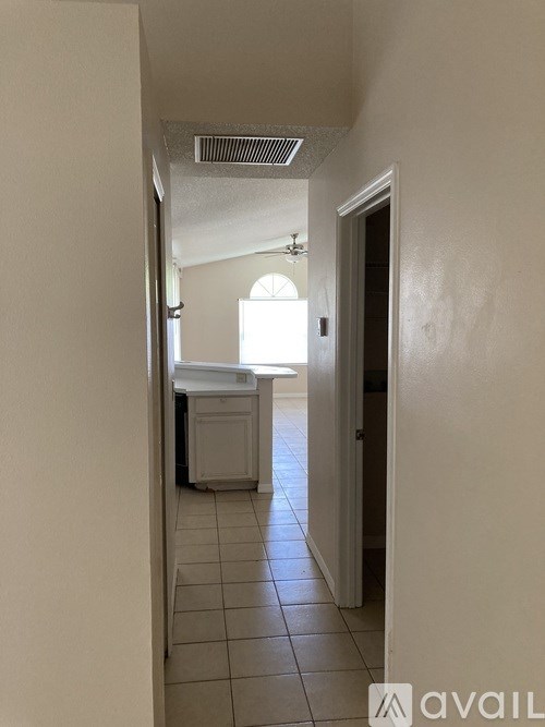 A hallway with a door on the right and a window on the left.