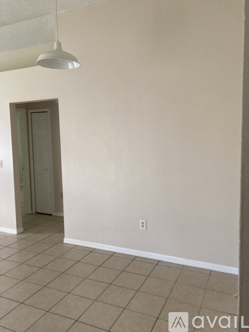 A room with a door and a light hanging from the ceiling.