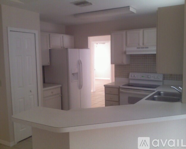 A kitchen with white appliances and cabinets.