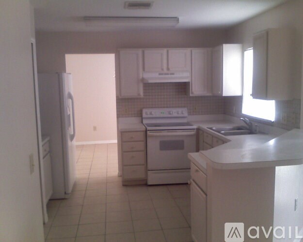 A kitchen with white appliances and cabinets.