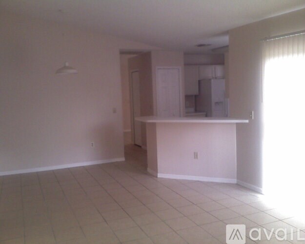 A white room with a kitchenette and a window.