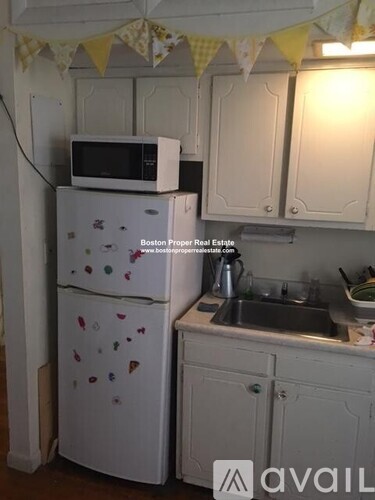 A kitchen with a white fridge and cabinets.