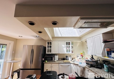 A kitchen with a refrigerator, microwave, and sink.