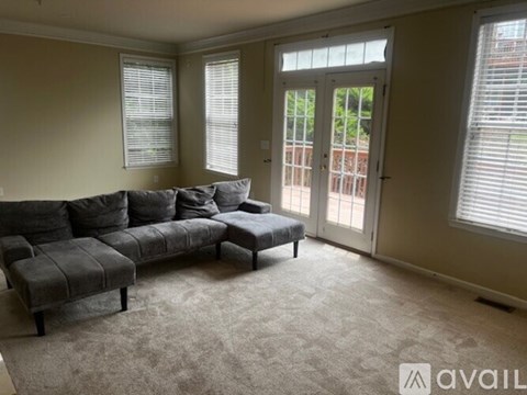 A living room with a grey sofa and a carpet.