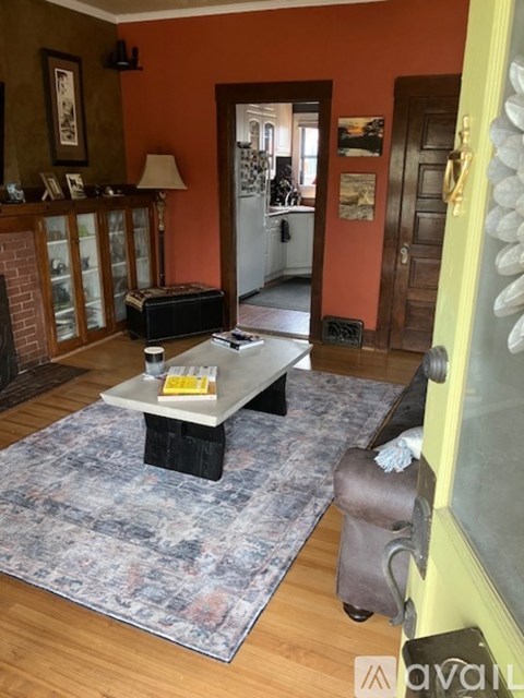 A living room with a grey rug and a white coffee table.