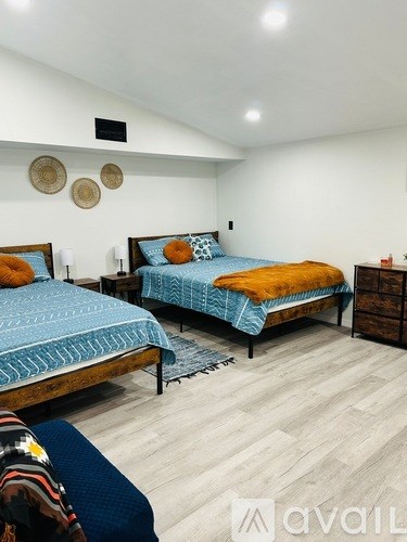 A bedroom with two beds and a wooden dresser.