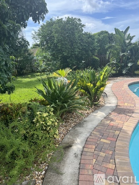 A garden with a pool and a brick border.