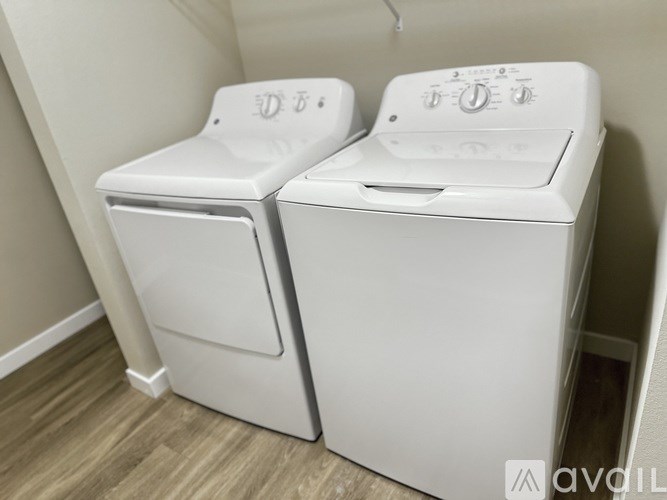 Two white front loading washing machines in a laundry room.