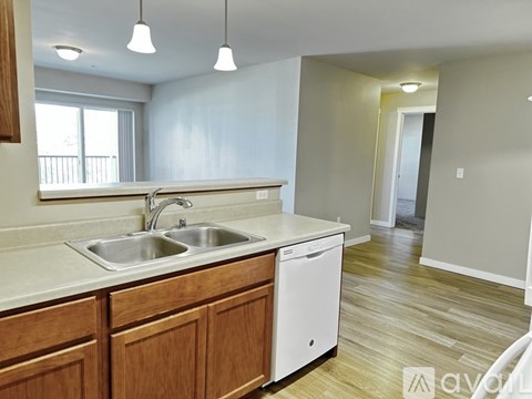 A kitchen with wooden cabinets and a white dishwasher.