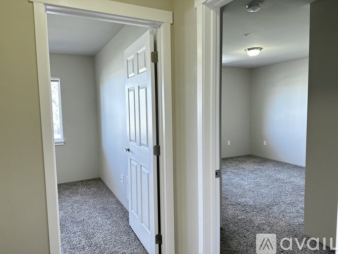 A room with a carpeted floor and a white door.